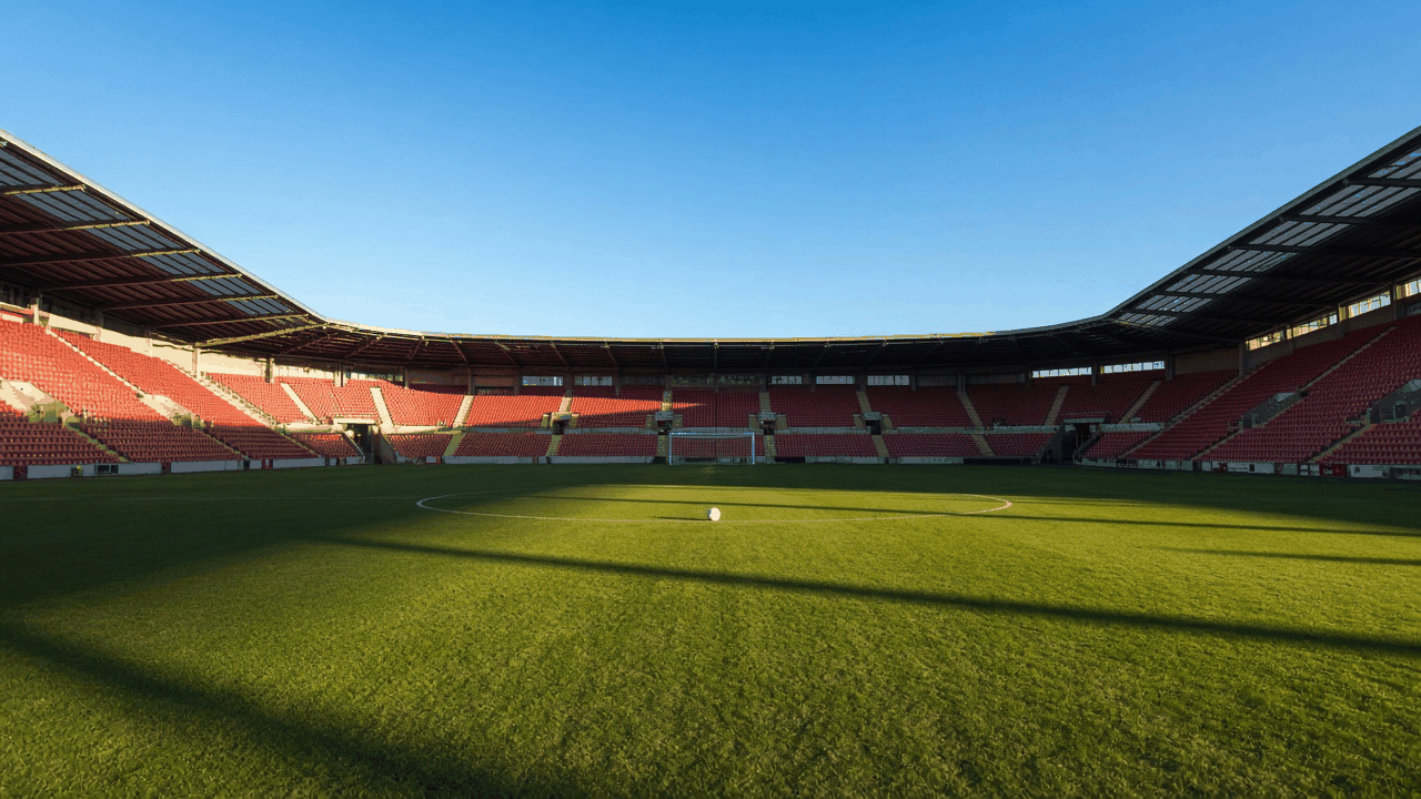 Empty Liverpool soccer stadium under match-day lights, with no people, text or logos